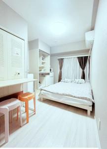 a white bedroom with a bed and a desk at Shinjuku Center 新宿中心#Shinjuku kabukicho#3 min walk from subway##高速无限制网路#新装修高级公寓#大楼一层入口自动锁门Newly renovated#404 in Tokyo