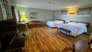 a hotel room with two beds and a couch at Laurie's Inn in Chéticamp +40 photos