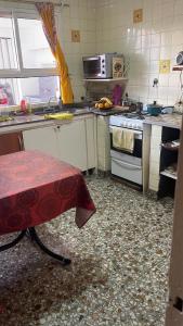 a kitchen with a stove and a table in it at Business Home in Olivos