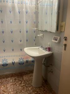 a bathroom with a sink and a shower curtain at Business Home in Olivos