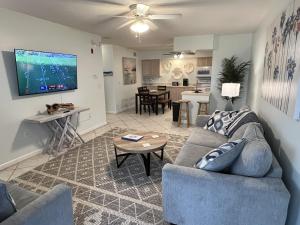 una sala de estar con un sofá y una mesa en Beachside 1-Bedroom Condo in Cocoa Beach, Florida - 125 Feet to Beach!, en Cocoa Beach