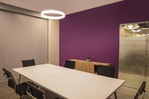 a meeting room with white tables and chairs and a purple wall at Fiesta Inn Express Monterrey Centro in Monterrey