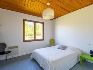 una camera da letto bianca con un letto e una finestra di Maison au bord du lac de Biscarrosse - 6 pers - Jardin et parking - Proche pistes cyclables - FR-1-319-511 a Biscarrosse