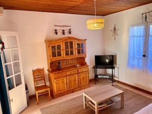 a living room with a wooden cabinet and a tv at Maison calme près plage - 6 pers - Animaux admis - FR-1-540-284 in Notre-Dame-de-Monts