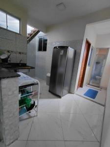 a kitchen with a stainless steel refrigerator in a room at Casa da Deusa in Belém
