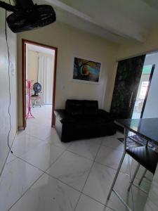 a living room with a black couch and a table at Casa da Deusa in Belém