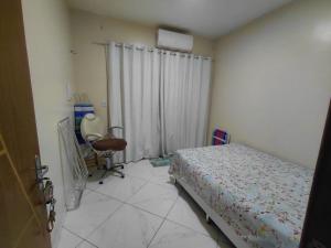 a bedroom with a bed and a chair in it at Casa da Deusa in Belém