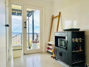 Una sala de estar con microondas y balcón. en Hobart Retreat with City and Water View, en West Hobart