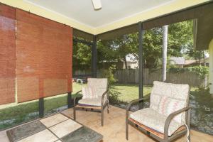 zwei Stühle und ein Tisch auf einer Terrasse in der Unterkunft Tropical Fruit Garden in Sarasota
