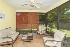 eine abgeschirmte Veranda mit Stühlen und einem Deckenventilator in der Unterkunft Tropical Fruit Garden in Sarasota