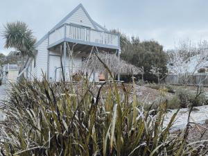 a house with a balcony on top of it at Barefoot Bungalow in Bicheno