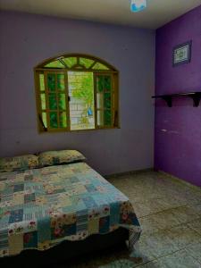 a bedroom with a bed and a window at Casa de tartaruga em Guarapari in Guarapari +8 photos