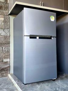 a stainless steel refrigerator sitting next to a wall at Song View Pool Villa in Vang Vieng