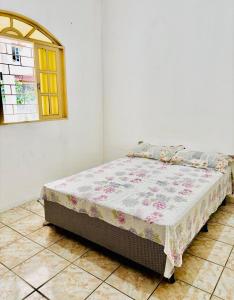 a bed sitting in a room with a window at Casa de tartaruga em Guarapari in Guarapari