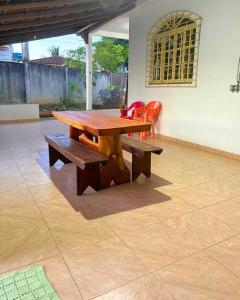 a wooden table and benches on a patio at Casa de tartaruga em Guarapari in Guarapari