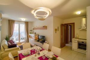 a kitchen and living room with a table and chairs at Harmony Apartment in Split