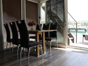 un comedor con una mesa con sillas negras en The Seaborn Residence - Two Bedroom Floating House, en Portorož