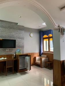 a hospital room with a tv and a table and chairs at Khách Sạn Quốc Hồng in Soc Trang