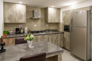 a kitchen with a refrigerator and a table with flowers on it at Departamento Confort Colinas in Chihuahua