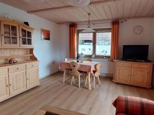 a kitchen with a table and chairs and a television at Holiday home Corinna in Kirchdorf im Wald