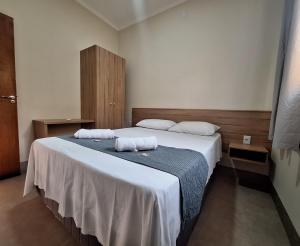 a bedroom with a large bed with two towels on it at Flats de 2 quartos in Regente Feijó