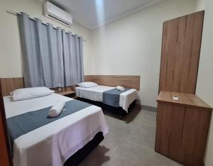 a hotel room with two beds and a window at Flats de 2 quartos in Regente Feijó