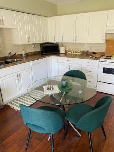 a kitchen with a glass table and two chairs at Peterborough Cosy Apartment in Peterborough