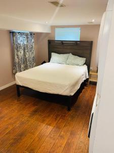 a bedroom with a bed and a wooden floor at Peterborough Cosy Apartment in Peterborough