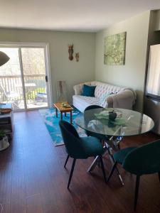 a living room with a glass table and a couch at Peterborough Cosy Apartment in Peterborough
