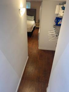 a hallway with a room with a bed and wooden floors at Peterborough Cosy Apartment in Peterborough