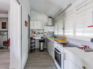 a kitchen with white cabinets and a large window at Maison Landaise Charme Proche Océan, Animaux Acceptés - FR-1-521-254 in Biscarrosse