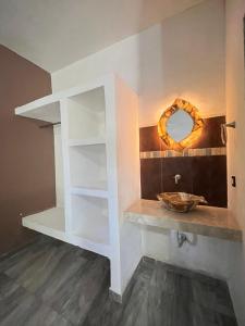 a bathroom with a sink and a wreath on the wall at Jungla maya hotel in Bacalar +16 photos