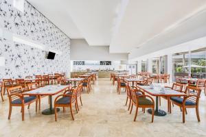 a dining room with wooden tables and chairs at Fiesta Inn Torreon Galerias in Torreón