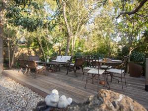 a wooden deck with chairs and tables and trees at Carqueiranne: Villa de Charme avec Piscine, Vue Mer, pour 8 Personnes - FR-1-599-119 in Carqueiranne