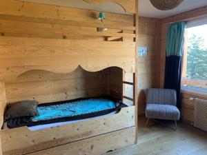 a bedroom with a bed in a wooden cabin at Appartement spacieux à Pra-Loup, terrasse sud, 10 pers - FR-1-165A-202 in Pra-Loup