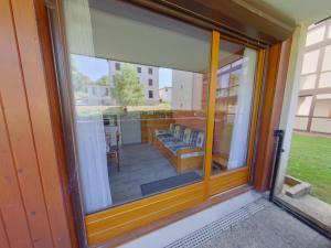 eine Glasschiebetür mit Blick auf eine Terrasse in der Unterkunft Appartement cosy aux Rousses avec terrasse et proximité activités - FR-1-834-8 in Les Rousses