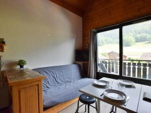 un salon avec un canapé, une table et une fenêtre dans l'établissement Appartement duplex à Bernex - 4 personnes, garage, près des pistes - FR-1-498-88, à Bernex