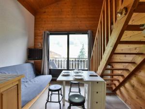 - un salon avec un canapé et une table avec des tabourets dans l'établissement Appartement duplex à Bernex - 4 personnes, garage, près des pistes - FR-1-498-88, à Bernex
