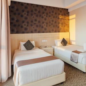 a hotel room with two beds and curtains at THE REED HOTEL Melaka in Malacca