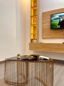 a living room with a table and a tv at Sucram Appartement in Abomey-Calavi