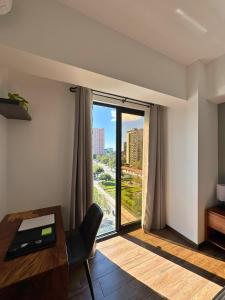 a room with a desk and a large window at Luxury One-Bedroom City Views, Pool & AC in Estación Pamplona