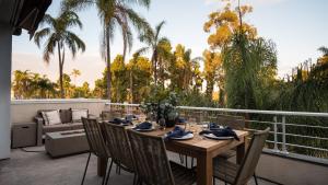 a wooden table on a balcony with palm trees at Balboa Buyout by AvantStay - Condo w Views in DT San Diego in San Diego