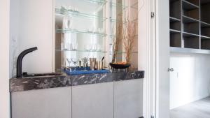 a kitchen with a counter with glass shelves at Balboa Buyout by AvantStay - Condo w Views in DT San Diego in San Diego +27 photos