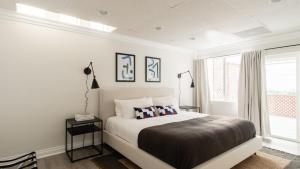 a white bedroom with a large bed and a window at Balboa Buyout by AvantStay - Condo w Views in DT San Diego in San Diego