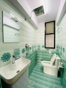 La salle de bains verte est pourvue d'un lavabo et de toilettes. dans l'établissement Hotel Durbar Side, à Bhaktapur