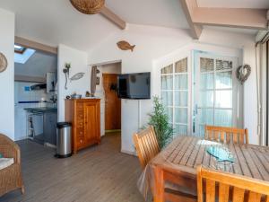 una cucina e una sala da pranzo con tavolo e sedie di Appartement 6 personnes à Mimizan avec parking, balcon et local à vélos - FR-1-50-126 a Mimizan