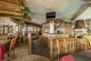 ein Restaurant mit Holztischen und -stühlen sowie einem TV in der Unterkunft Hotel Garni Chasa Nova in Samnaun