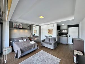 a bedroom with a bed and a chair and a couch at Yalla Stay - Cool Studio Habitarte in Sao Paulo +16 photos