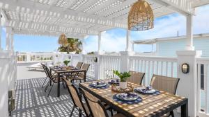 a patio with a table and chairs on a porch at 1 Block to Beach Newly Renovated 6BDR w Rooftop Views Sand Dune by AvantStay in Mount Pleasant