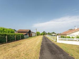 a dirt road with a fence and a house at Maison Charmante 3* à Mimizan: Plages, Pistes Cyclables, Jardin, Wi-Fi, pour 8 Personnes - FR-1-50-137 in Mimizan